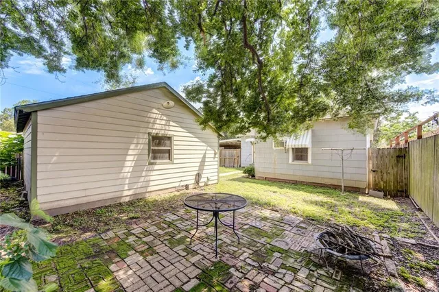 a backyard of a house with table and chairs