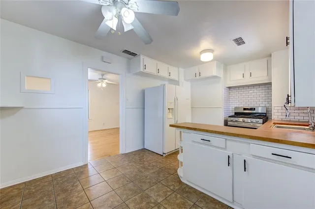 a kitchen with kitchen island white cabinets and refrigerator