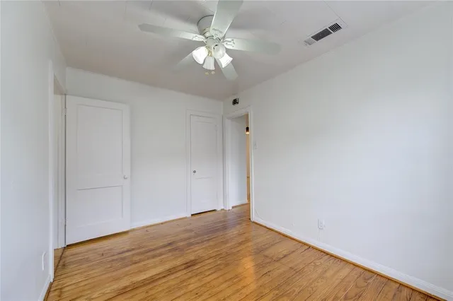 a view of an empty room with a chandelier fan