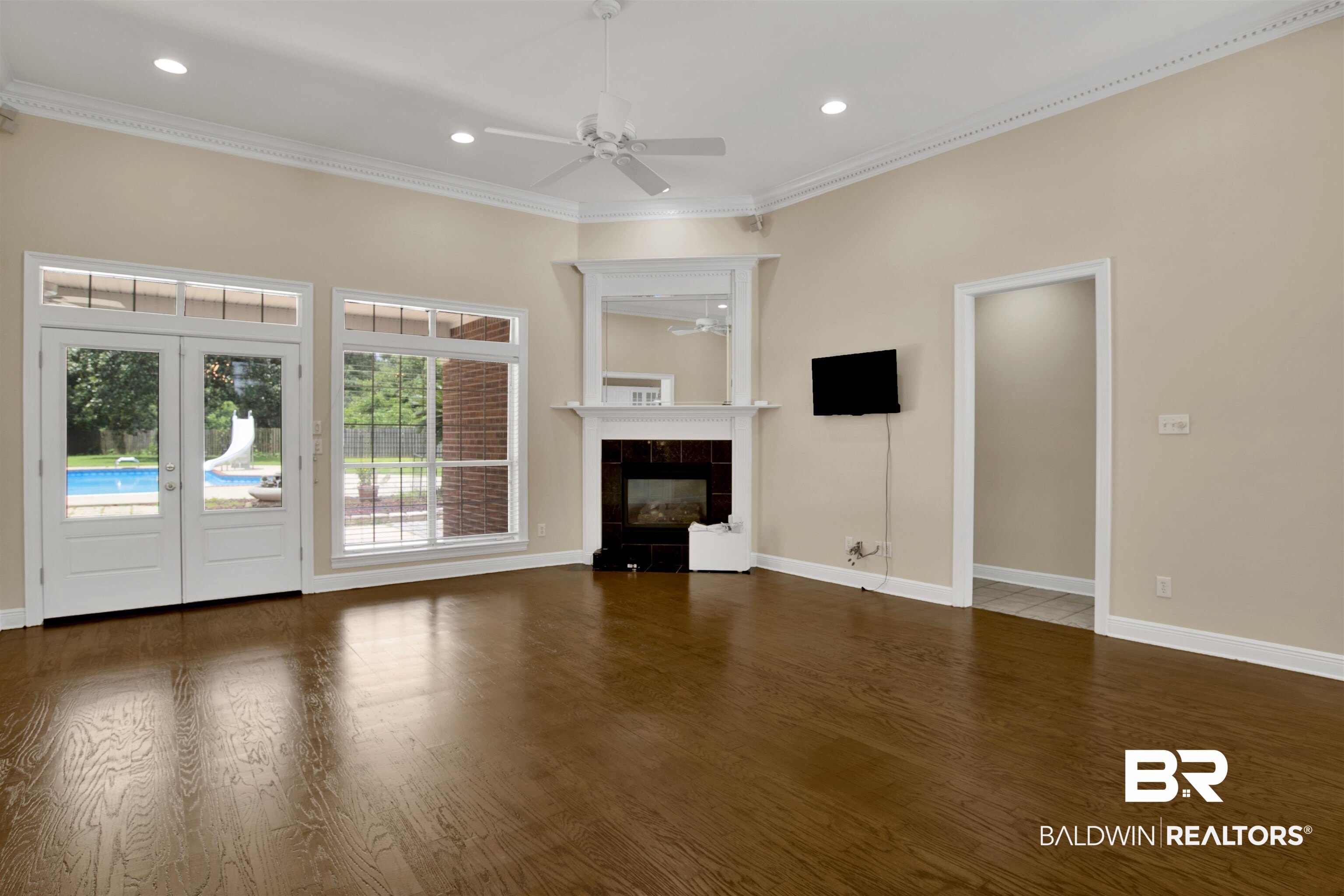 8847 Dawes Lake Road South Mobile, AL 36619 - Photo 36 of 47 Spacious living area featuring rich wood-finish flooring, a white mantel fireplace with a dark tile surround, and recessed lighting