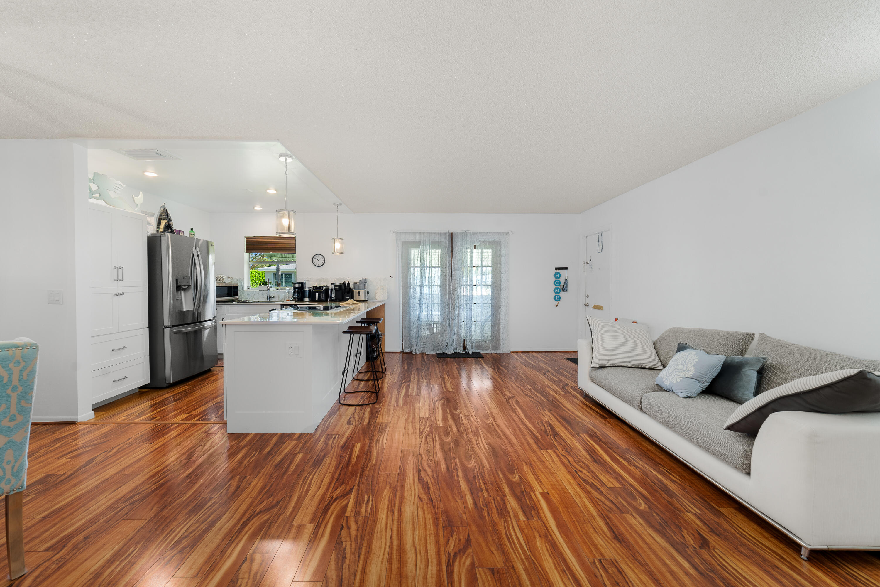 3331 Valley Road, Unit C Boynton Beach, FL 33435 - Photo 10 of 28 a living room with stainless steel appliances kitchen island granite countertop furniture a wooden floor and a sink