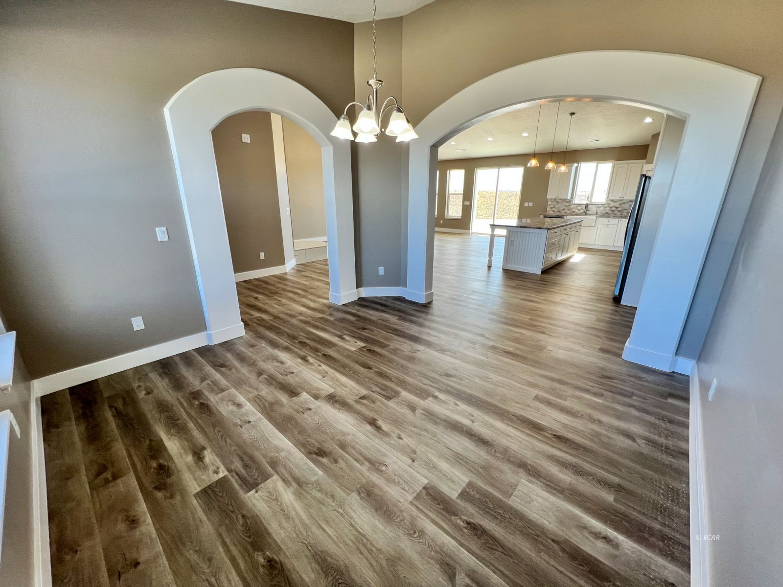 457 Sun Vly Road Spring Creek, NV 89815 - Photo 11 of 33 a view of a hallway with wooden floor and chandelier