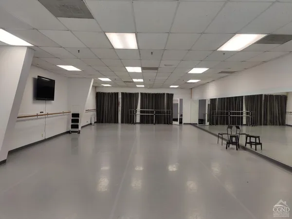 a view of an empty room with furniture and a window