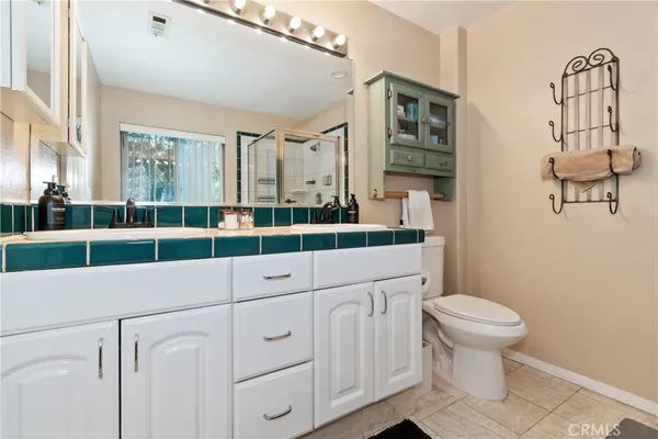 a bathroom with a sink a toilet and a large mirror