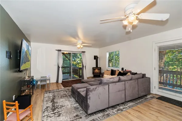 a living room with furniture large window and flat screen tv