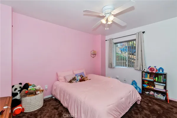 a bedroom with a bed dresser and a chandelier