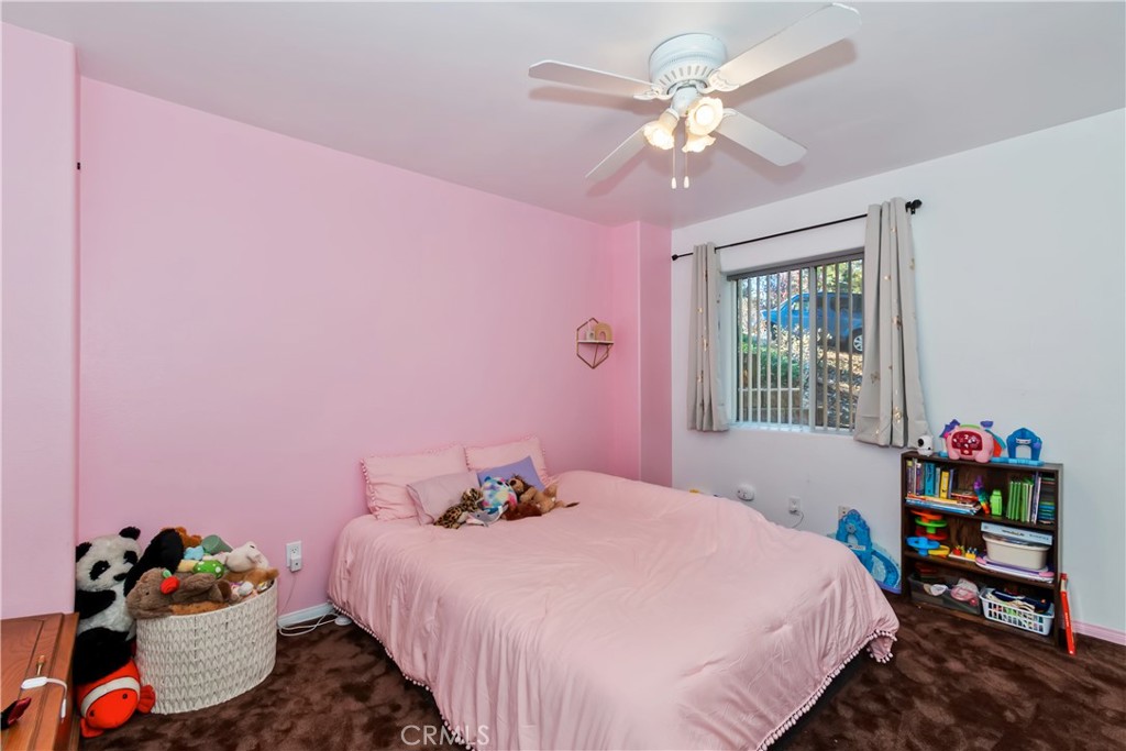 198 Pine Ridge Road Crestline, CA 92325 - Photo 21 of 45 a bedroom with a bed dresser and a chandelier