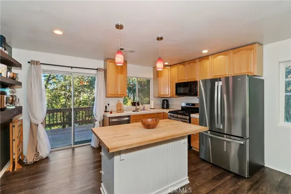 a kitchen with stainless steel appliances a stove refrigerator and wooden floor