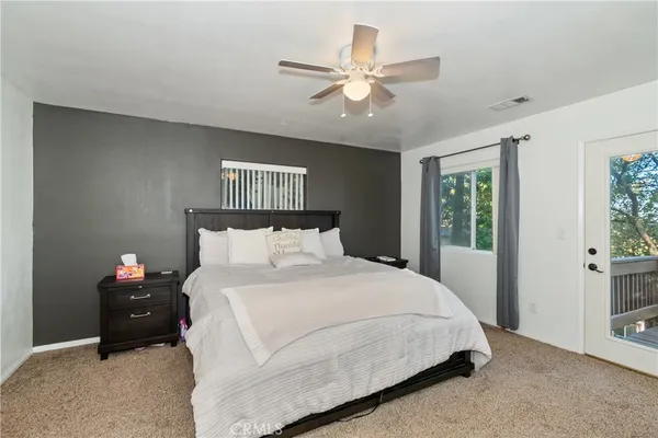 a bedroom with a bed and a ceiling fan
