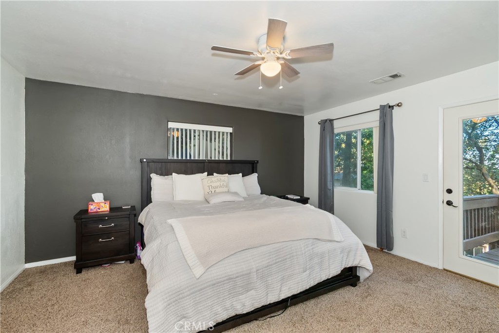 198 Pine Ridge Road Crestline, CA 92325 - Photo 9 of 45 a bedroom with a bed and a ceiling fan