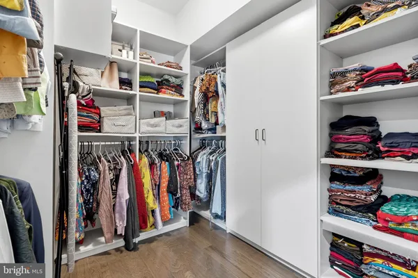 a view of walk in closet with clothes and shoes