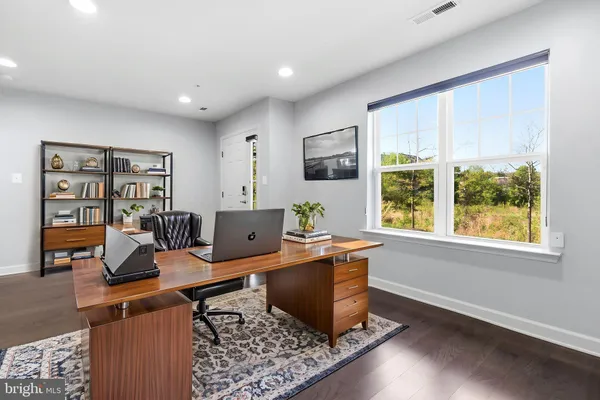 a view of a workspace with furniture and a window
