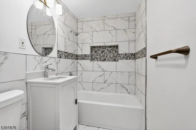 a bathroom with a sink and mirror with bathtub