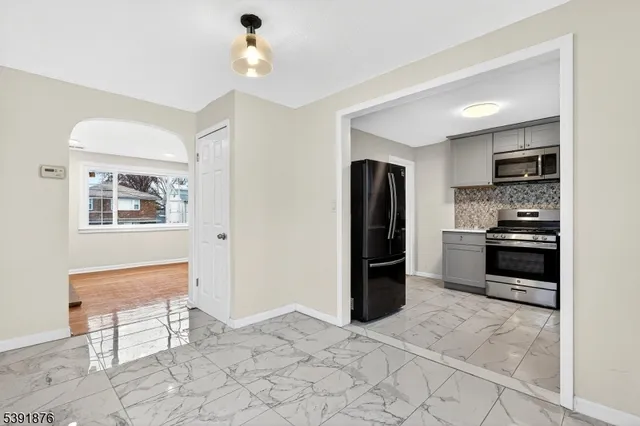 a kitchen with stainless steel appliances kitchen island granite countertop a refrigerator and a stove top oven