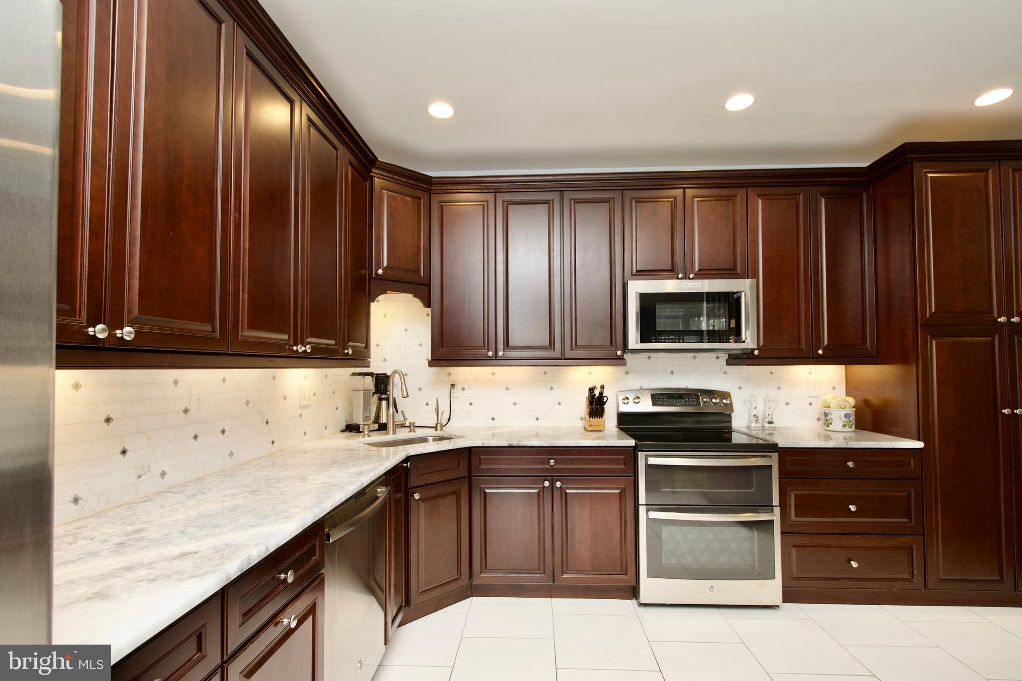 8005 Strauff Road, Unit 17 Towson, MD 21204 - Photo 7 of 49 a kitchen with granite countertop wooden cabinets and stainless steel appliances