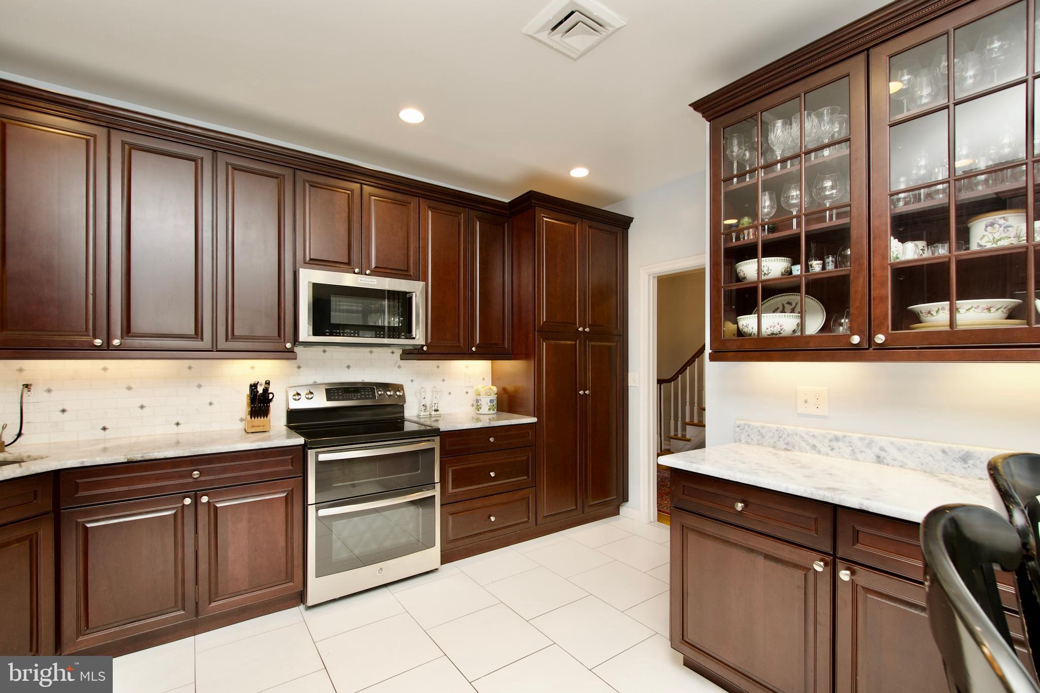 8005 Strauff Road, Unit 17 Towson, MD 21204 - Photo 9 of 49 a kitchen with granite countertop wooden cabinets and stainless steel appliances