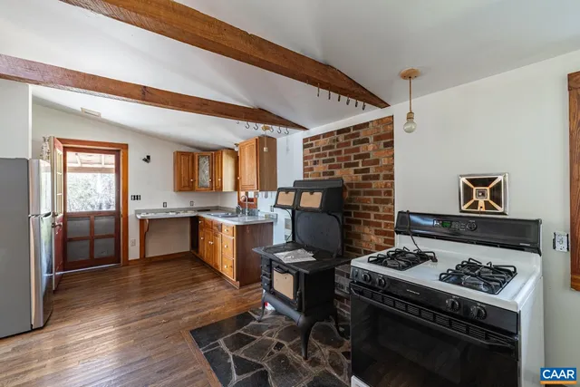 a kitchen with a stove and a wooden floors