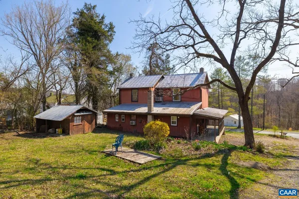a front view of a house with garden yard and tree
