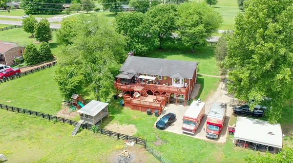 an aerial view of a house with backyard space and lake view