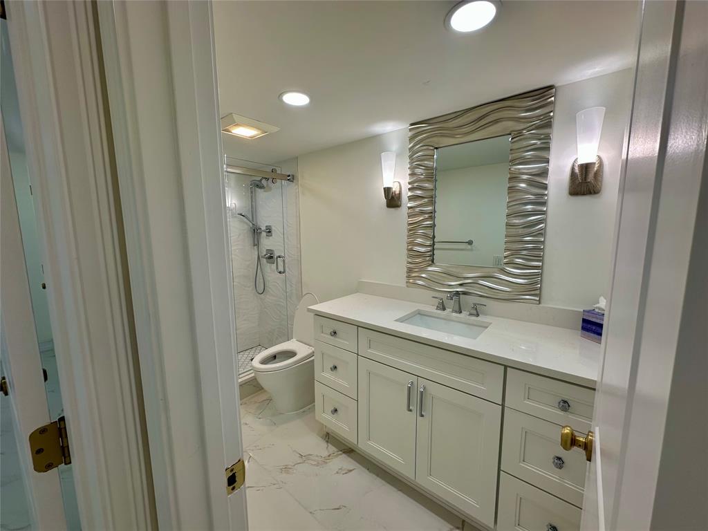 303 North Riverside Drive, Unit 1002 Pompano Beach, FL 33062 - Photo 19 of 27 a bathroom with a granite countertop sink toilet and shower