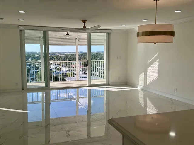 a open kitchen with stainless steel appliances granite countertop a sink a flat screen tv and a large window