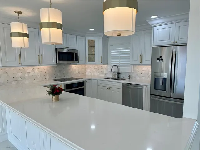 a kitchen with stainless steel appliances a refrigerator sink and microwave