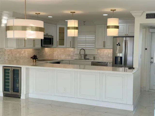 a kitchen with stainless steel appliances granite countertop a sink a stove and a refrigerator