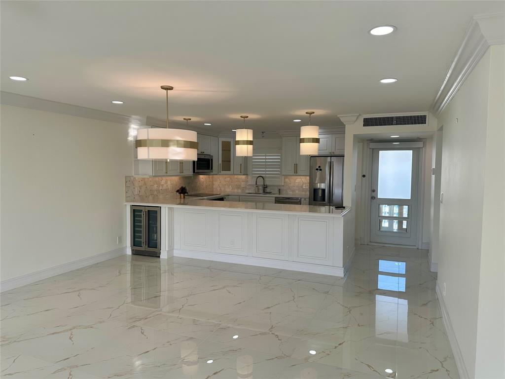 303 North Riverside Drive, Unit 1002 Pompano Beach, FL 33062 - Photo 7 of 27 a large kitchen with kitchen island a sink stainless steel appliances and cabinets