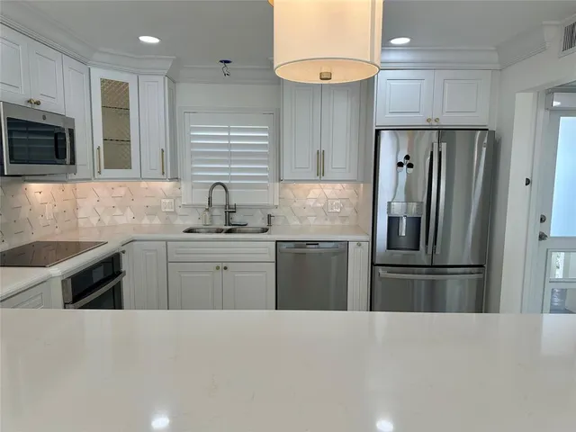 a kitchen with stainless steel appliances granite countertop a refrigerator sink and microwave