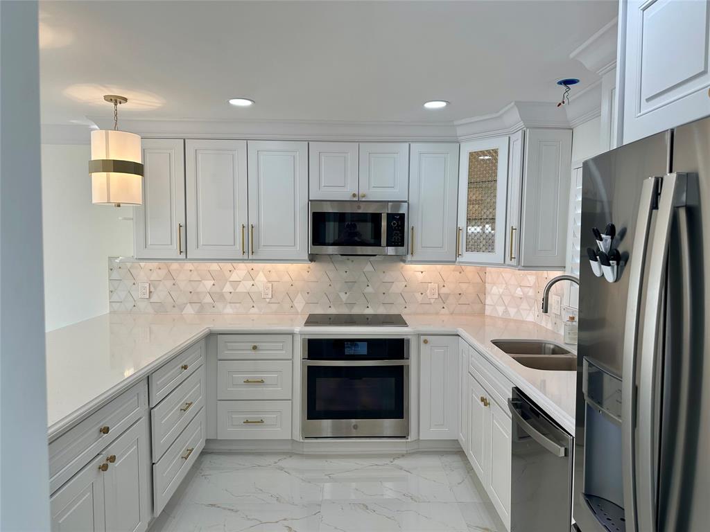 303 North Riverside Drive, Unit 1002 Pompano Beach, FL 33062 - Photo 9 of 27 a kitchen with stainless steel appliances granite countertop a refrigerator and a stove top oven