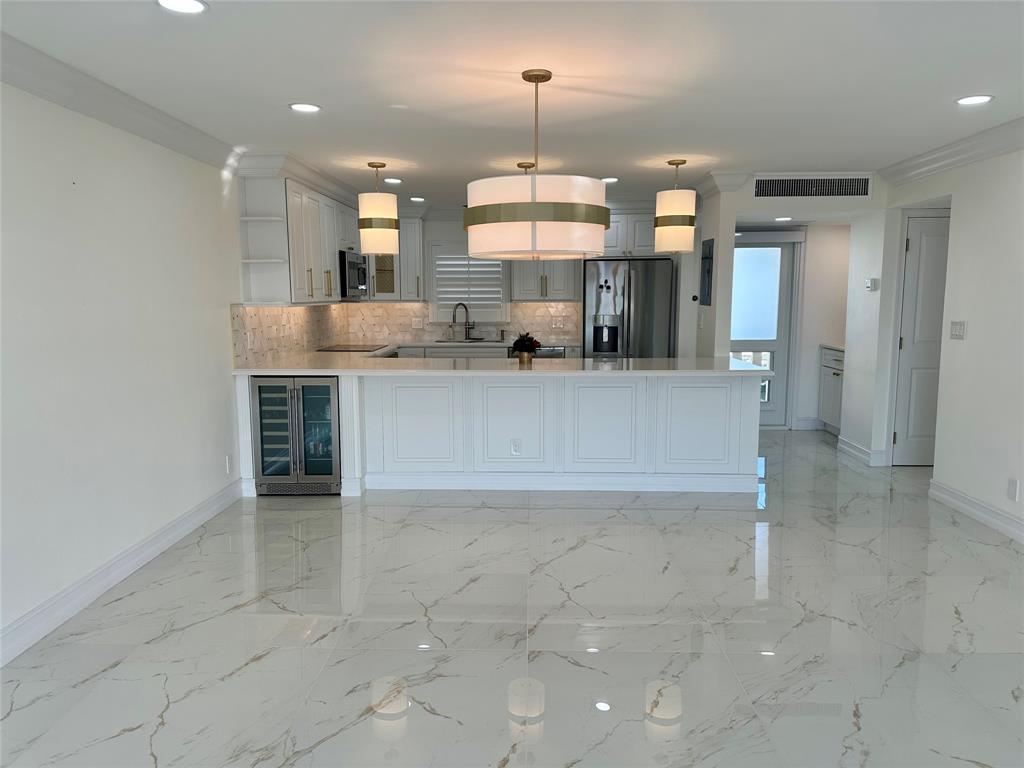 303 North Riverside Drive, Unit 1002 Pompano Beach, FL 33062 - Photo 10 of 27 a large kitchen with kitchen island a sink stainless steel appliances and cabinets