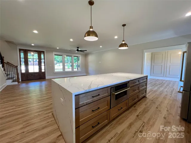 a kitchen with stainless steel appliances a refrigerator sink and wooden floor