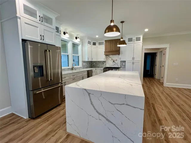 a kitchen with stainless steel appliances granite countertop a refrigerator and a sink