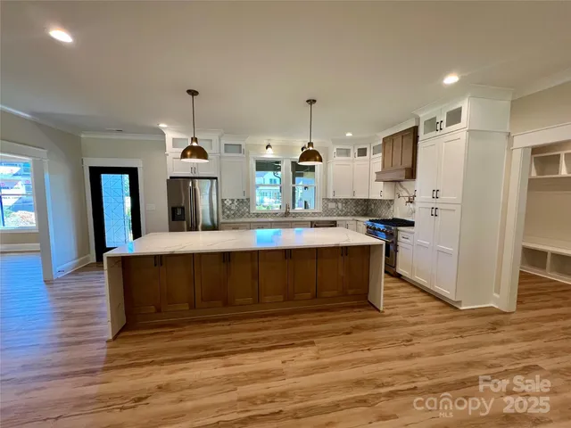 a large kitchen with kitchen island a sink stainless steel appliances and cabinets