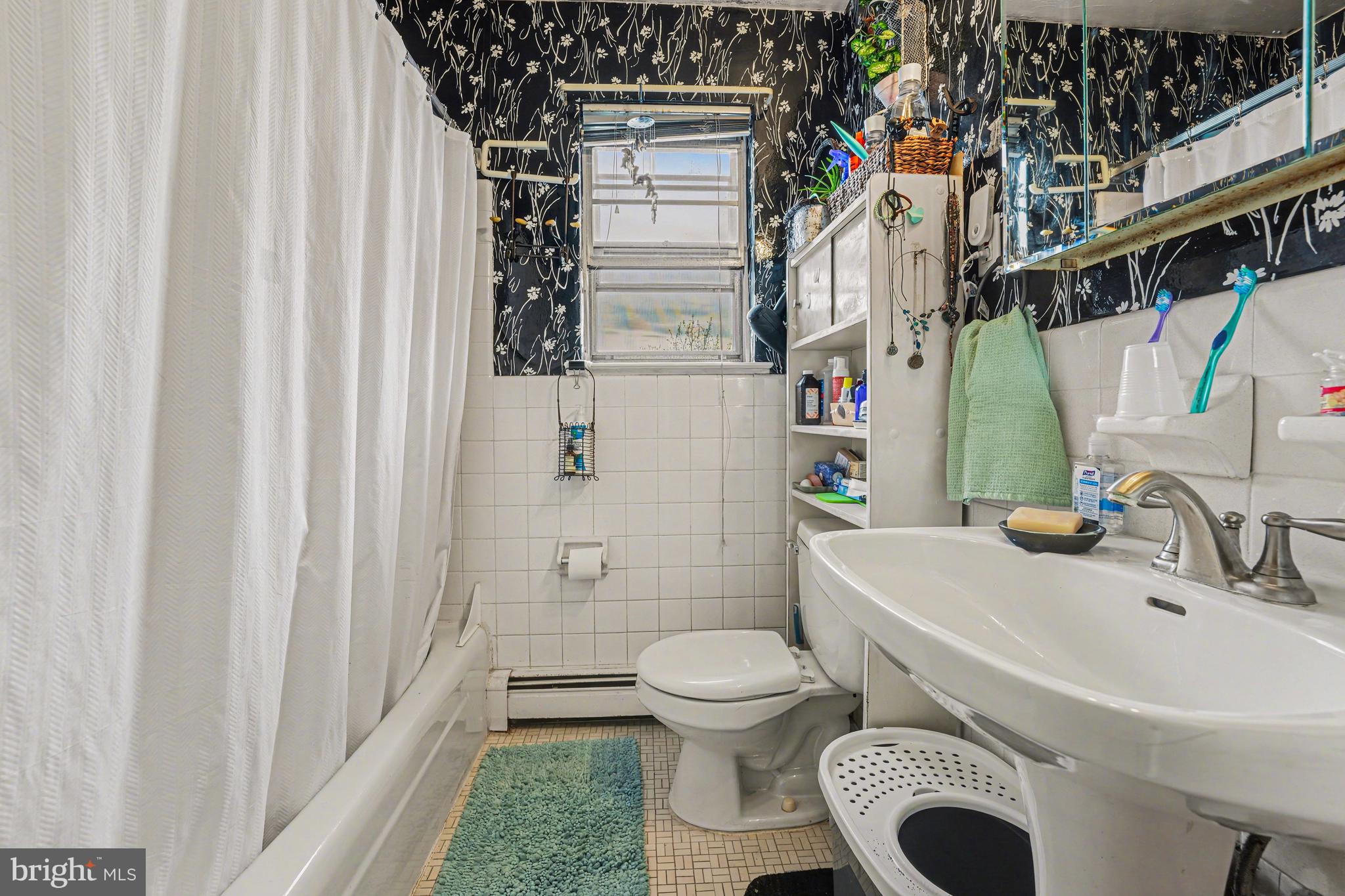 107 Allison Road Oreland, PA 19075 - Photo 39 of 54 a bathroom with a sink a toilet and shower curtain