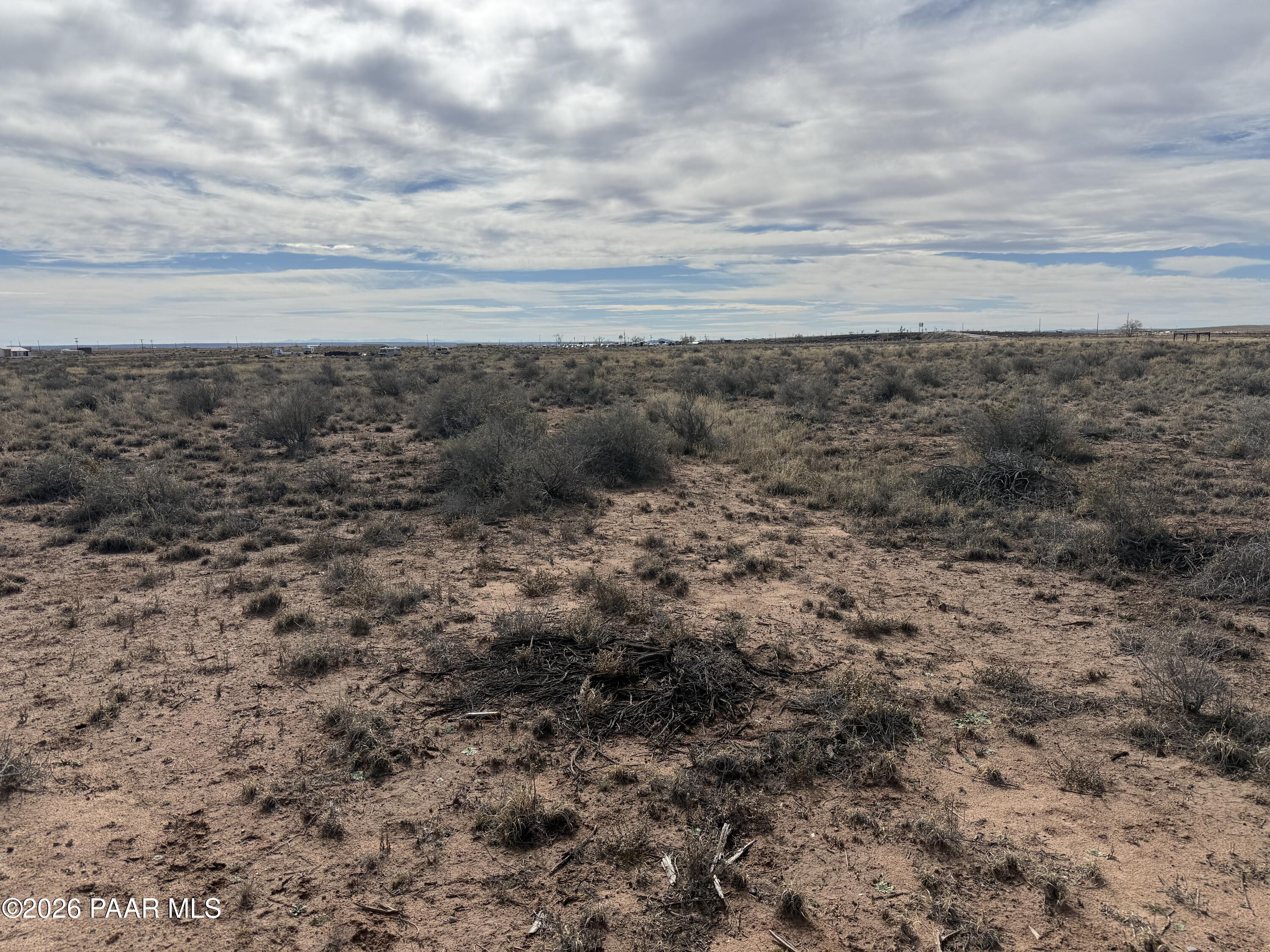 7625 Pima Street Holbrook, AZ 86029 - Photo 1 of 7 a view of a dry yard with wooden floor and fence