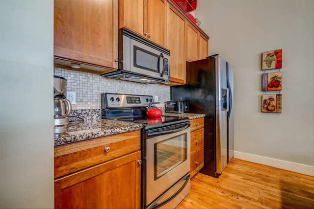 a kitchen with a stove and wooden floor