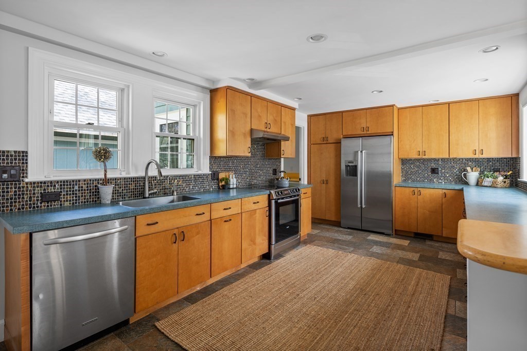 67 Randlett Park Newton, MA 02465 - Photo 12 of 41 a kitchen with stainless steel appliances granite countertop a refrigerator a sink dishwasher a stove with wooden cabinets and floor