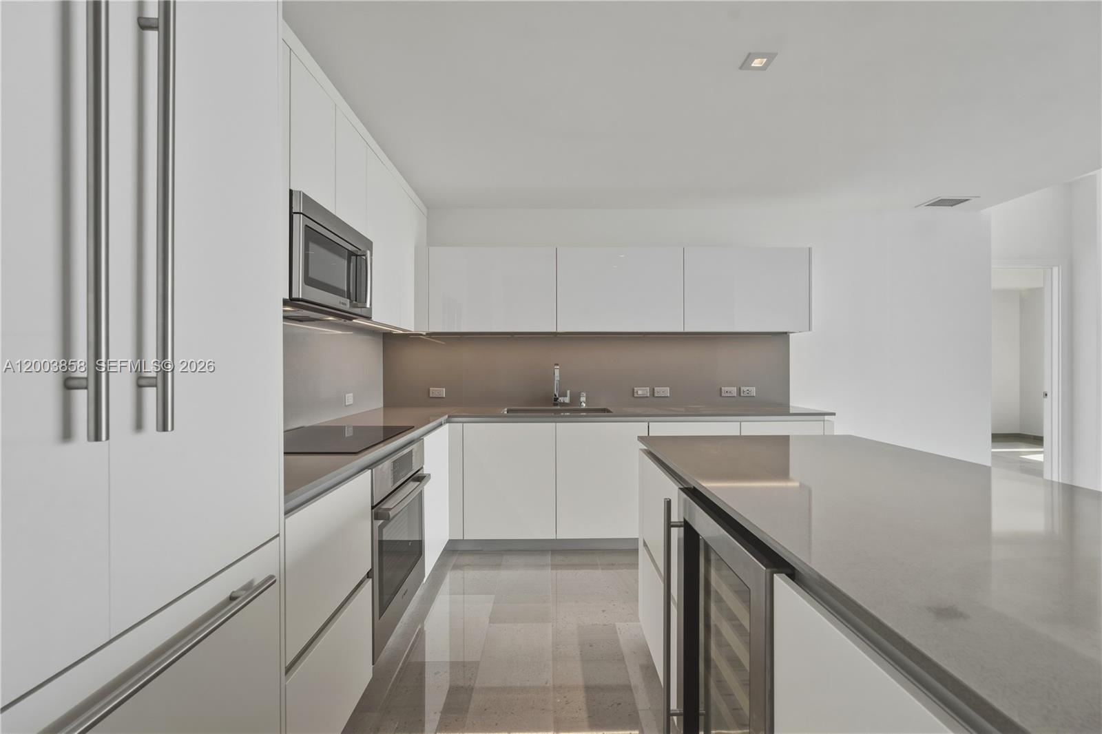 88 Southwest 7th Street, Unit 3710 Miami, FL 33130 - Photo 6 of 21 a kitchen with granite countertop a sink and white cabinets