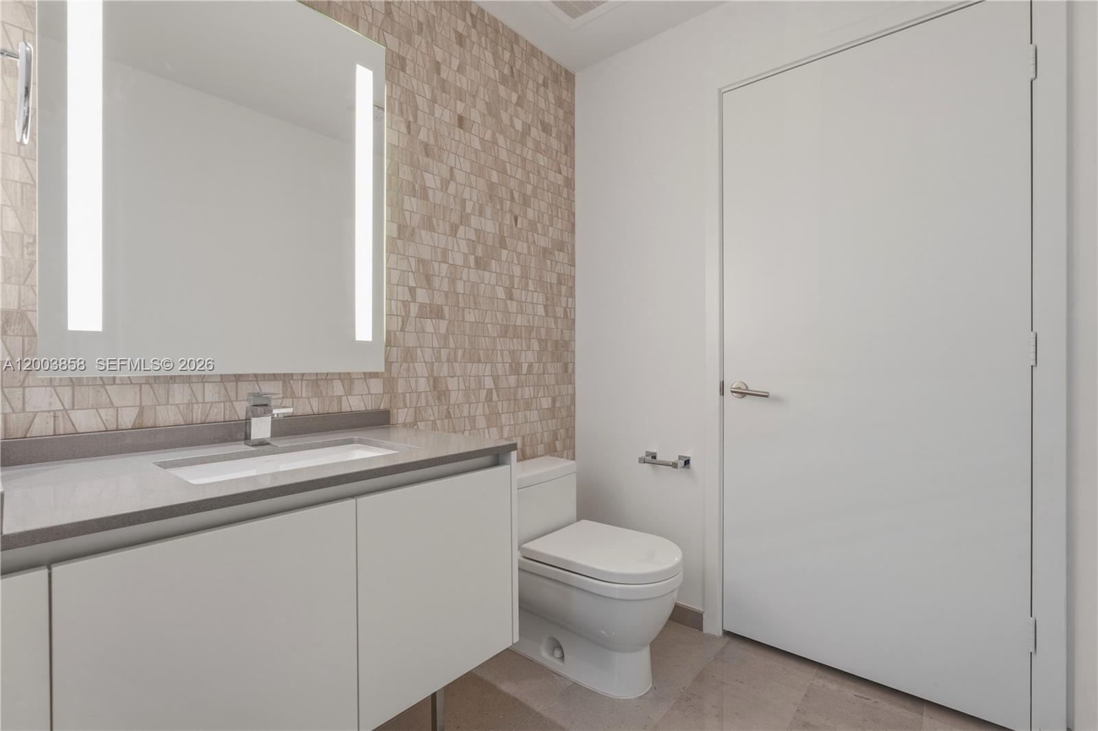 88 Southwest 7th Street, Unit 3710 Miami, FL 33130 - Photo 10 of 21 a bathroom with a toilet a sink and mirror