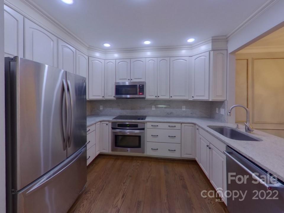 1012 Queens Road Charlotte, NC 28207 - Photo 5 of 13 a kitchen with stainless steel appliances granite countertop a refrigerator a stove and a sink with wooden floor