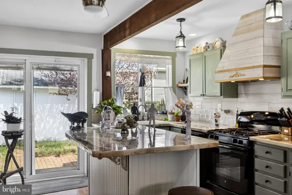 a kitchen with stainless steel appliances a sink a stove and a wooden floor