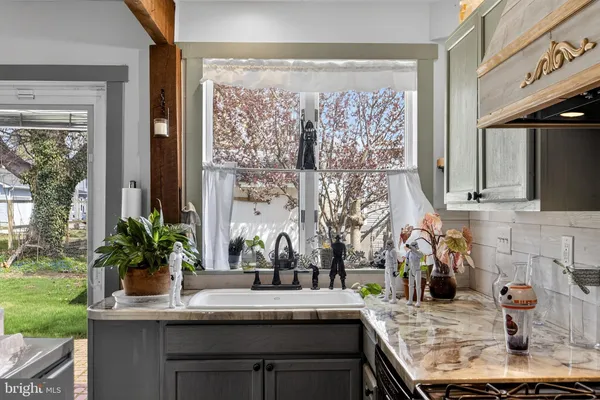 a kitchen with a sink and a large mirror next to a yard