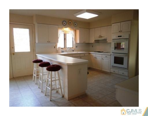 200 Old Forge Road Monroe Township, NJ 08831 - Photo 10 of 25 a kitchen with stainless steel appliances granite countertop a sink a stove a refrigerator a dining table and chairs