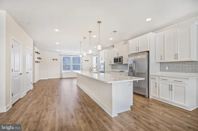 a large kitchen with kitchen island a sink a center island stainless steel appliances and a cabinets