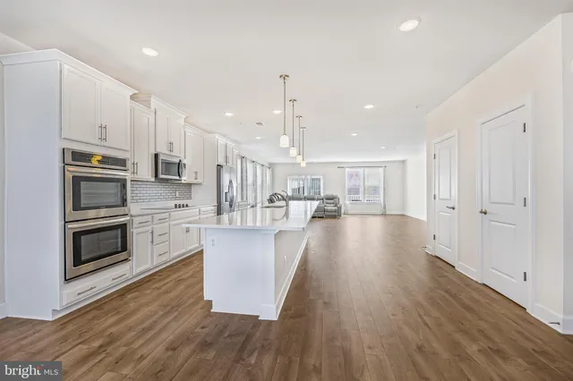 a view of kitchen with refrigerator microwave and stove top oven