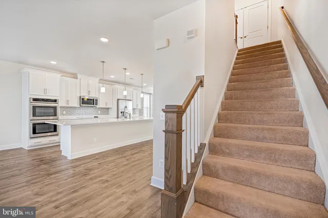 a view of a big room with windows and chandelier fan