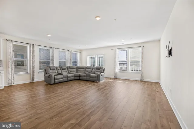 a view of a big room with wooden floor and windows