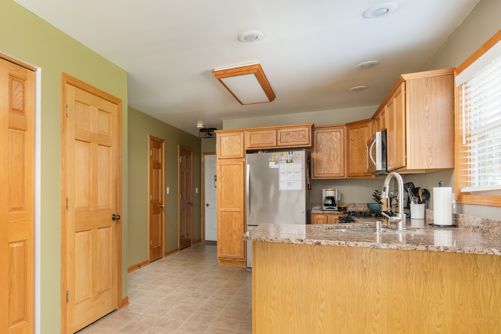 3421 Marquette Road Peru, IL 61354 - Photo 21 of 41 a kitchen with stainless steel appliances granite countertop a refrigerator a sink and a window