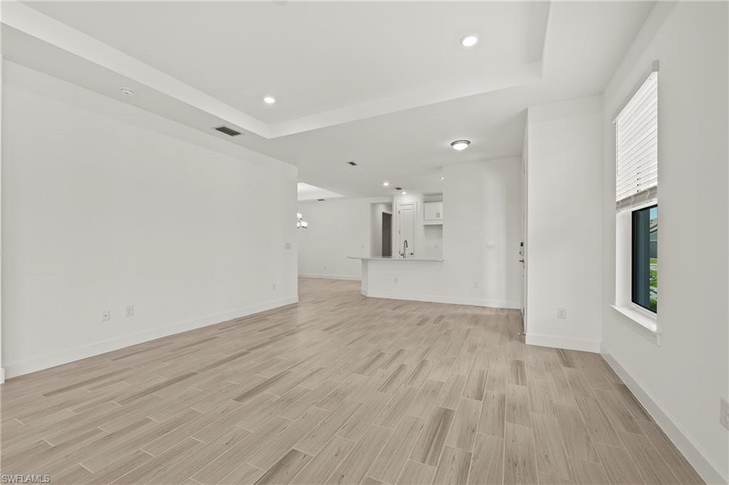 15517 Vittorio Street Naples, FL 34114 - Photo 19 of 35 Unfurnished living room featuring light wood finished floors, plenty of natural light, recessed lighting, and baseboards